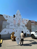 Flake i by yai yai is a large white six-pointed laser cut snowflake sculpture with perforated diamond cutouts and mini lights by gilbert engineering usa