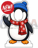 A cartoon penguin photo op prop wearing a blue knit hat with pom-pom and red scarf with white snowflakes for interactive photo fun