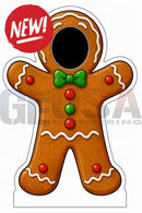 A gingerbread man-shaped interactive photo op prop with a black face hole, white icing details, and red candy dots
