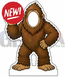 Brown furry bigfoot cutout photo op prop with blank face opening holding red new sign for interactive photo fun
