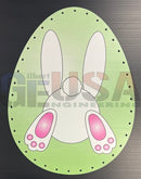 Light green oval impression easter egg with white bunny and black outline, featuring blue wavy zag and green zig zag accents