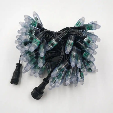 Bundle of LED string lights with clear bulbs and green circuit boards connected by black wiring.