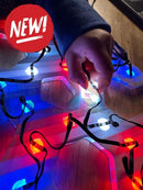 A hand holding colorful evo 12mm pixels with red blue and white led bulbs on black waterproof wiring